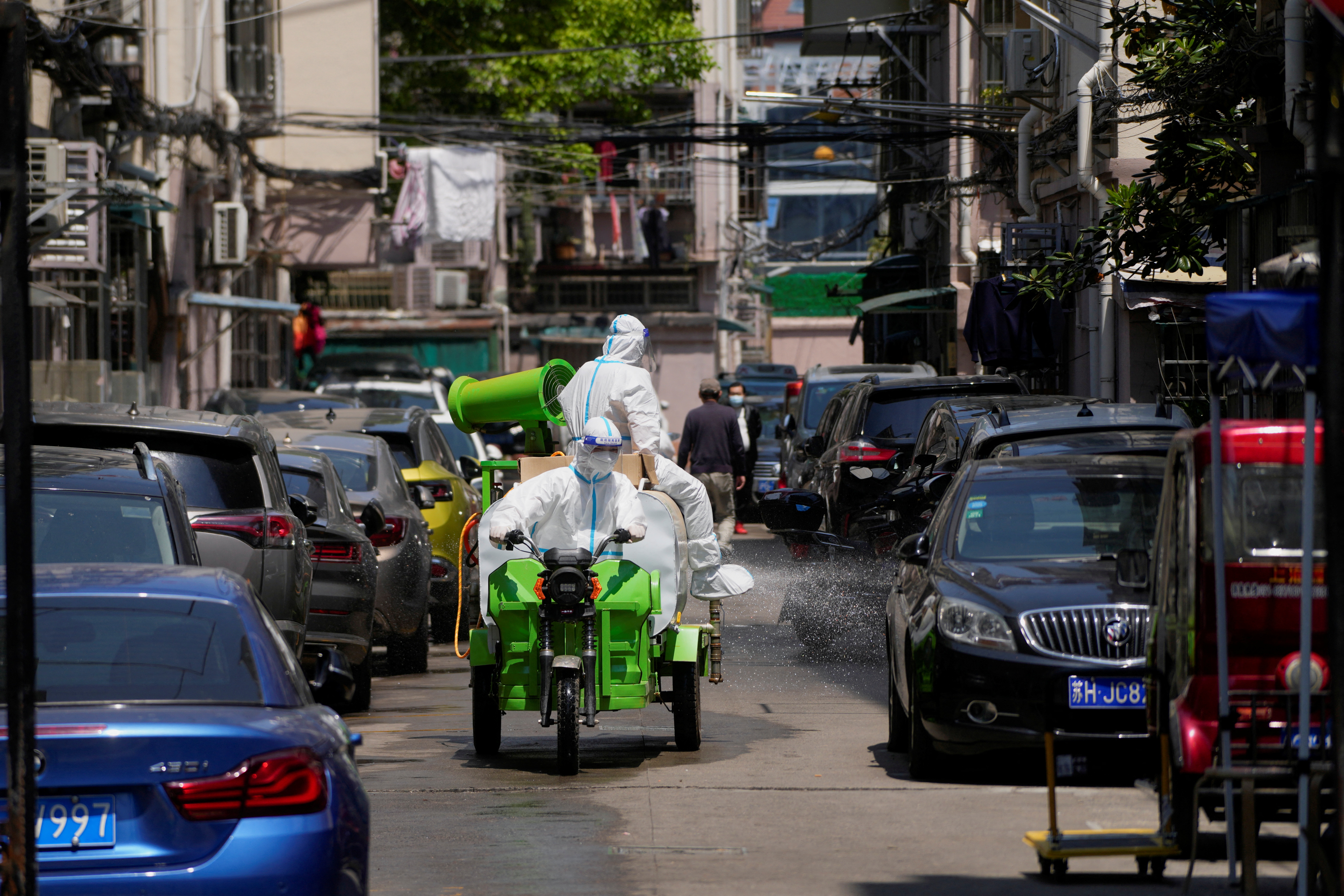Workers in protective suits disinfect a closed residential area during lockdown, amid the coronavirus disease (COVID-19) outbreak, in Shanghai, China, May 17, 2022. REUTERS/Aly Song