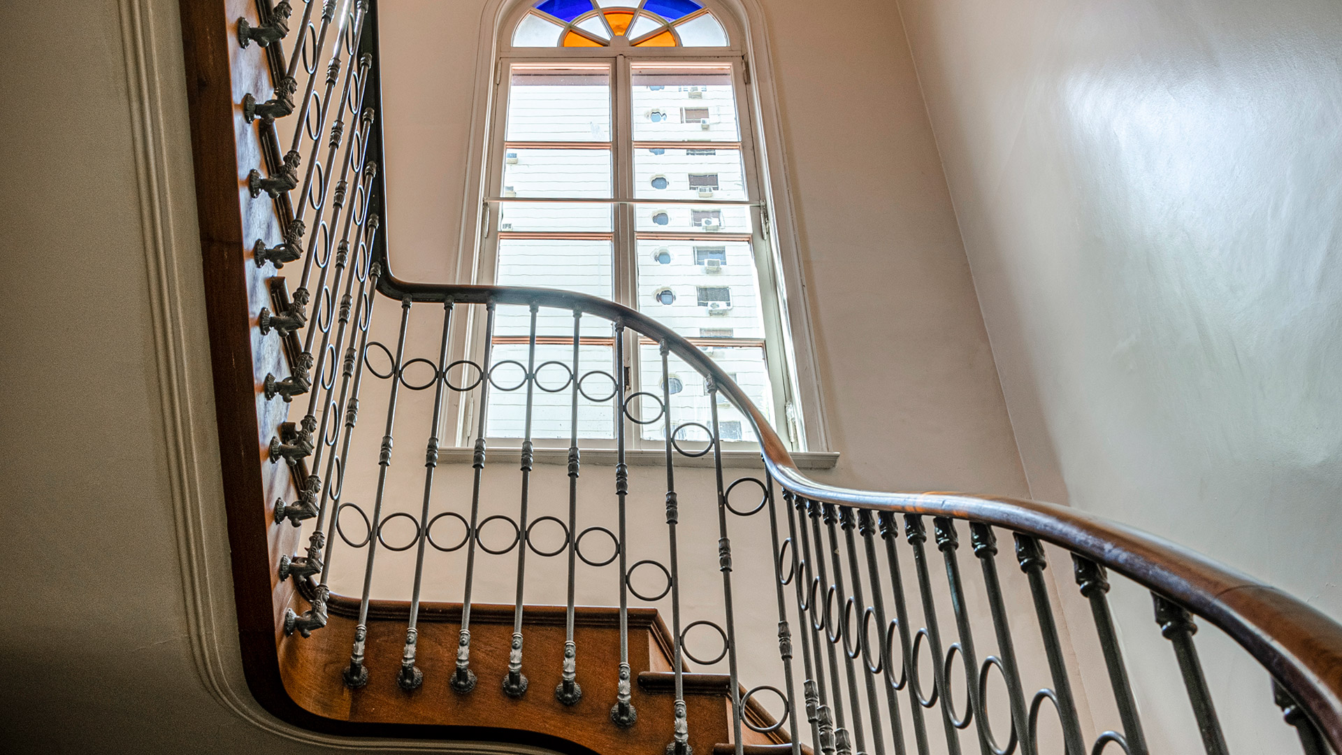 Con escaleras revestidas en madera y ventanas que combinan vitraux y vidrios
