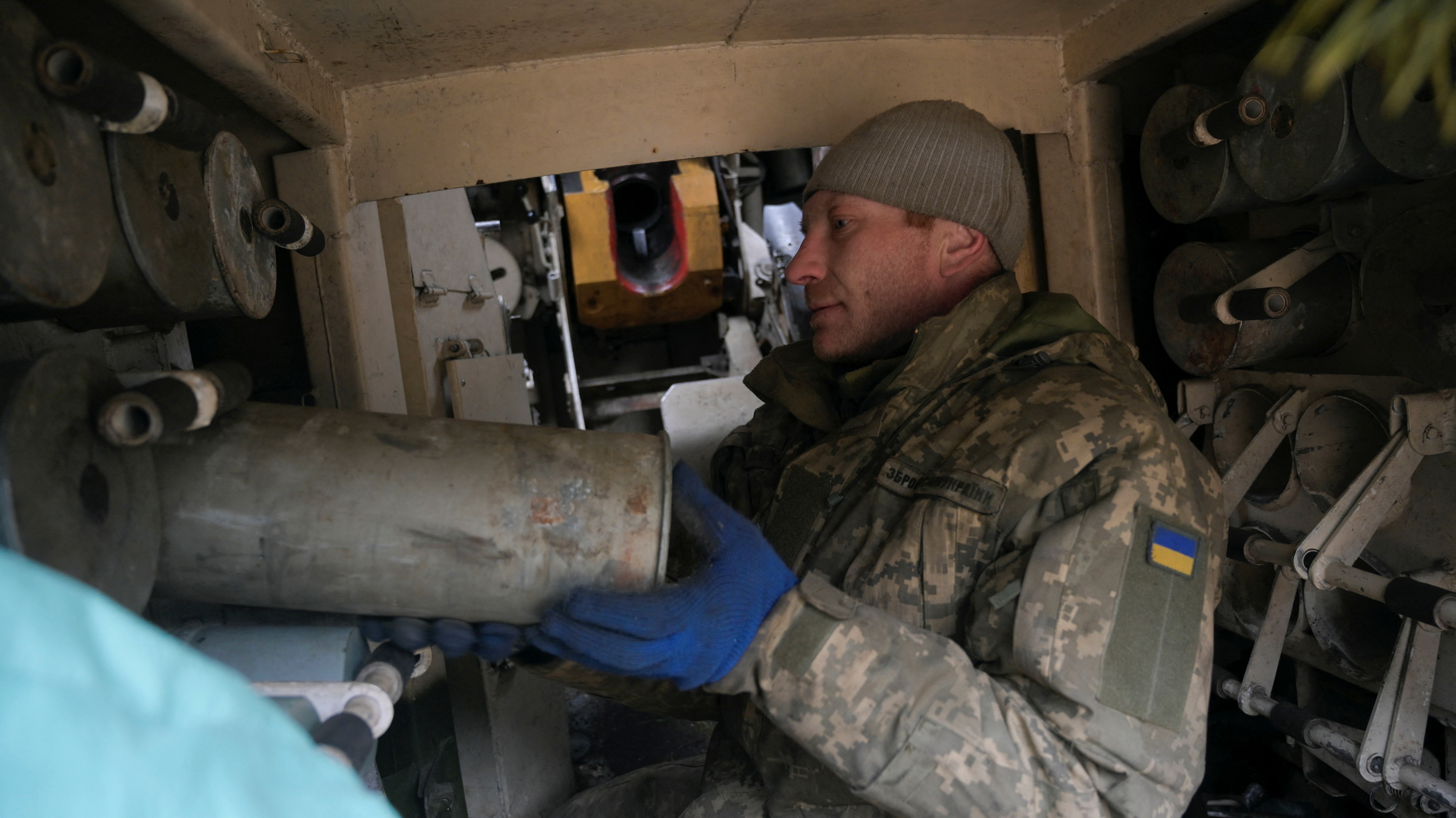 Un suboficial ucraniano alimenta de munición a la lanzadera de cohetes en la línea de defensa de Makariv. REUTERS/Maksim Levin