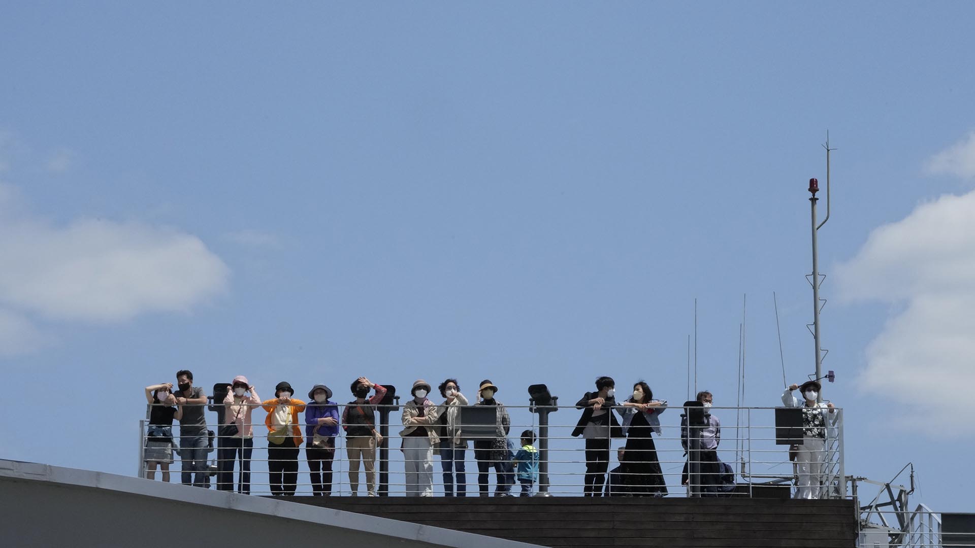 La gente mira al lado norcoreano en el Pabellón Imjingak en Paju, Corea del Sur, cerca de la frontera con Corea del Norte, el domingo 15 de mayo de 2022. (Foto AP/Ahn Young-joon)