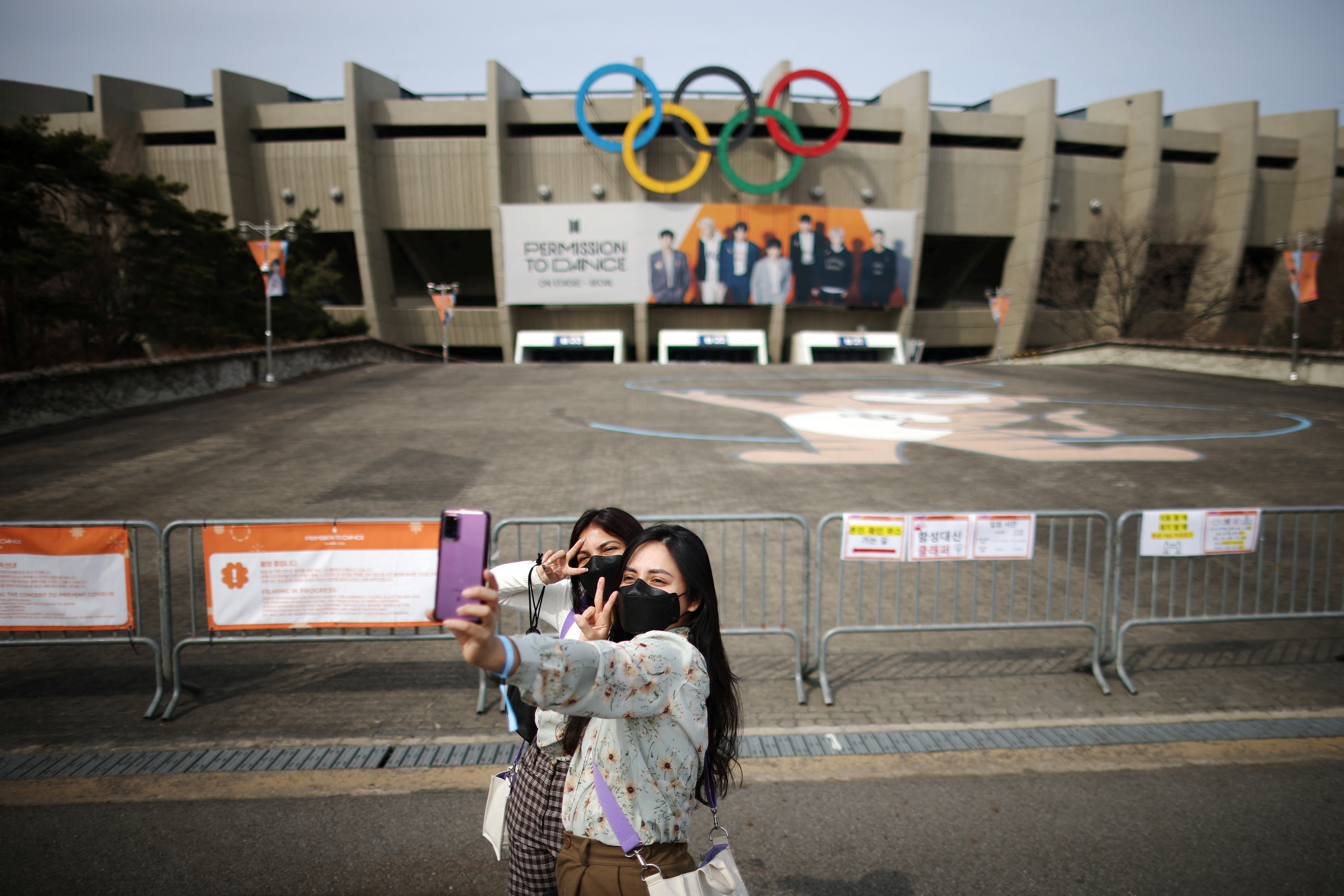 Fans de la banda de K-pop BTS se toman fotografías frente al Seoul Olympic Stadium en espera de su concierto. REUTERS