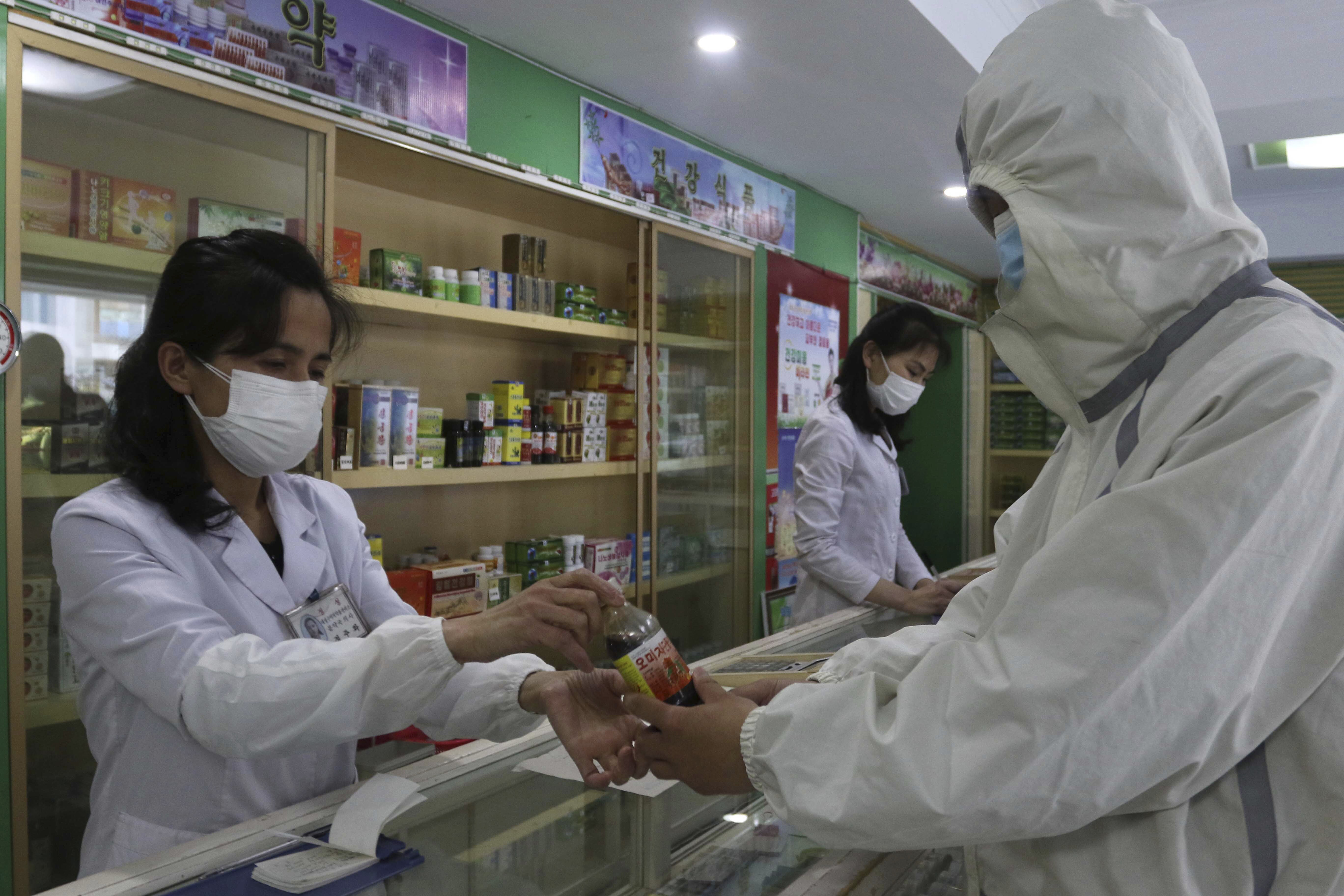 Un empleado de la Oficina de Gestión de Medicamentos del distrito de Daesong en Pyongyang proporciona medicamentos a un residente (Foto AP/Jon Chol Jin)