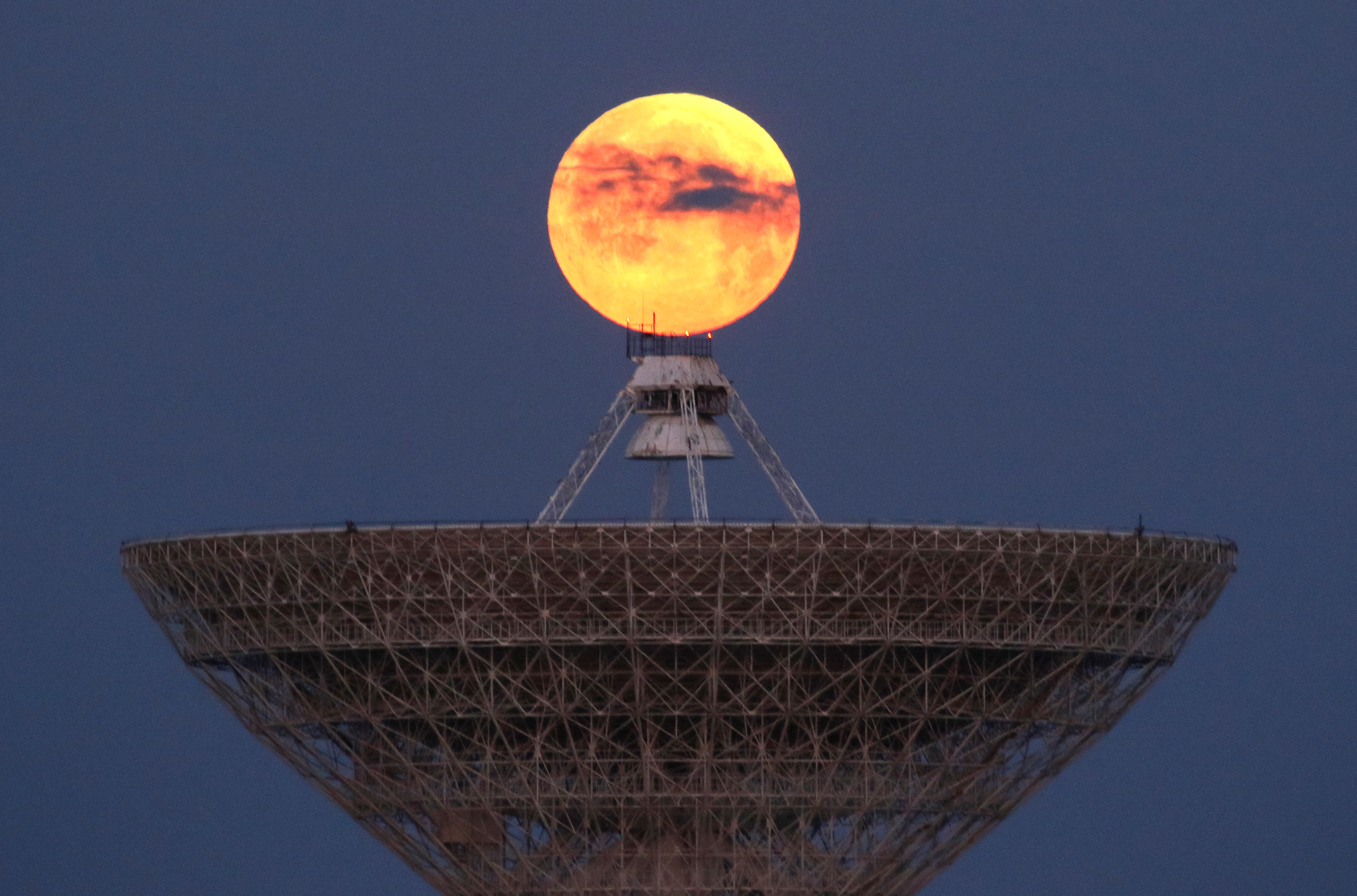 La luna se ve a través de las nubes detrás del radiotelescopio RT-70 en el pueblo de Molochnoye, Crimea (REUTERS/Alexey Pavlishak)