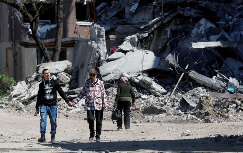 Residentes locales junto a un edificio destruido durante el conflicto entre Ucrania y Rusia en la ciudad portuaria del sur de Mariúpol (Foto: REUTERS/Alexander Ermochenko)