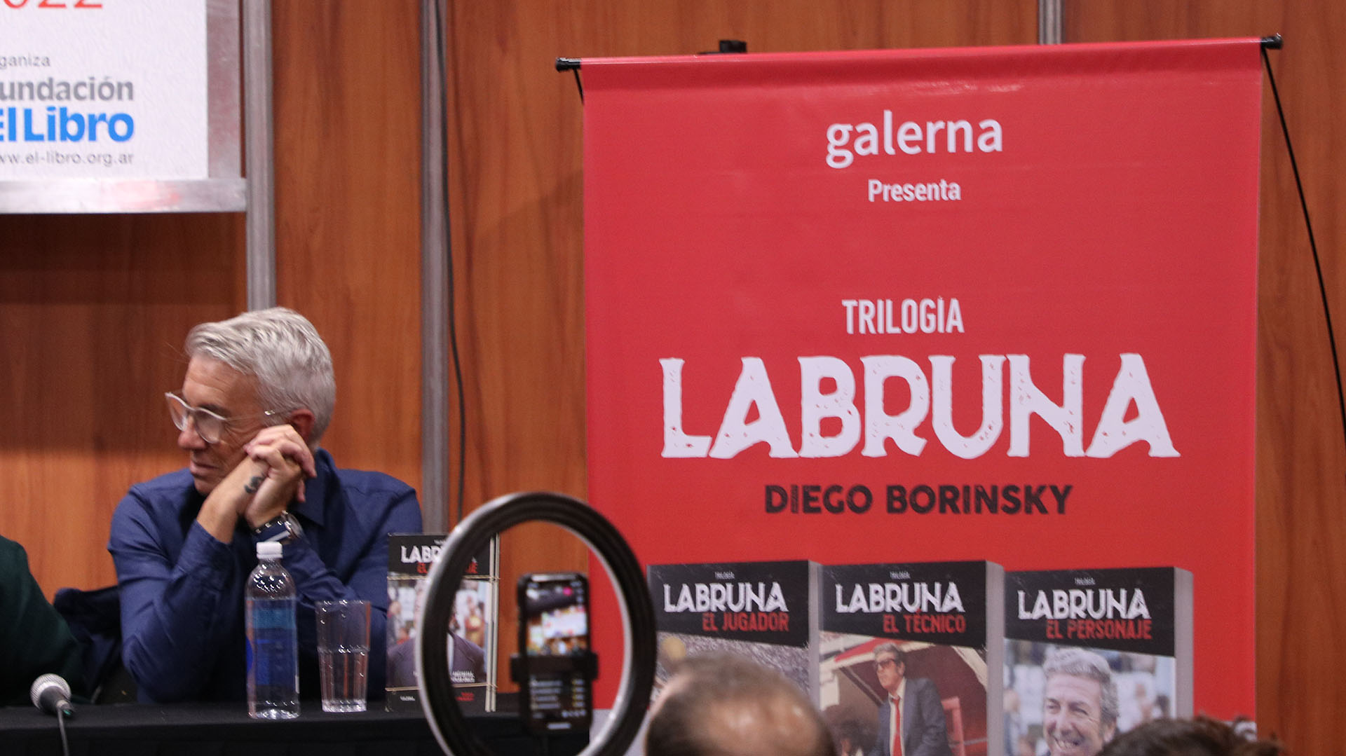 Las tapas de las tres obras, en medio de la presentación en la Feria del Libro
