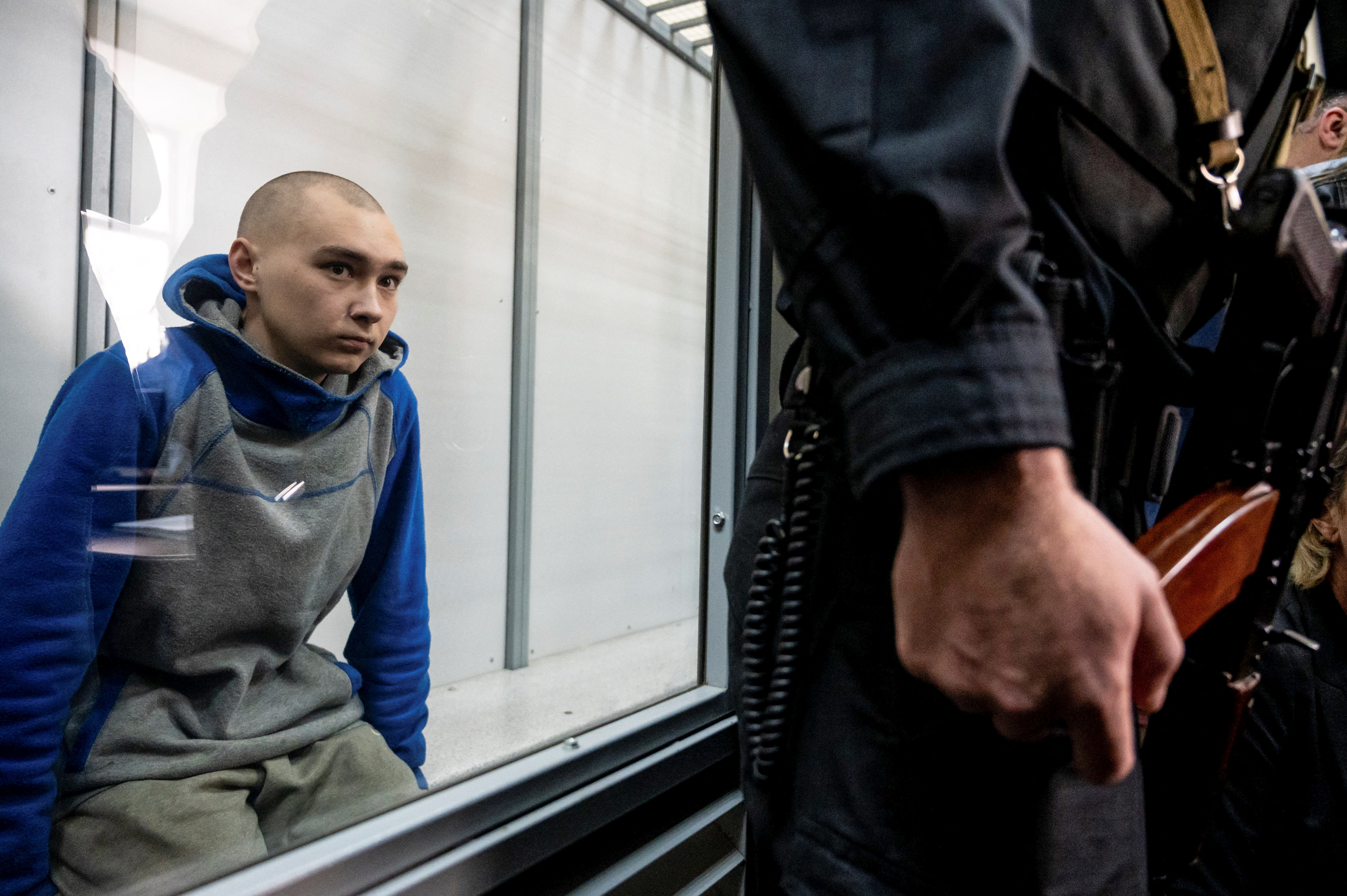 El soldado ruso Vadim Shishimarin, de 21 años, sospechoso de violaciones de las leyes y normas de la guerra, se sienta dentro de la jaula de los acusados ​​durante una audiencia judicial, en medio de la invasión rusa de Ucrania, en Kiev, Ucrania, el 13 de mayo de 2022. REUTERS/Viacheslav Ratynskyi