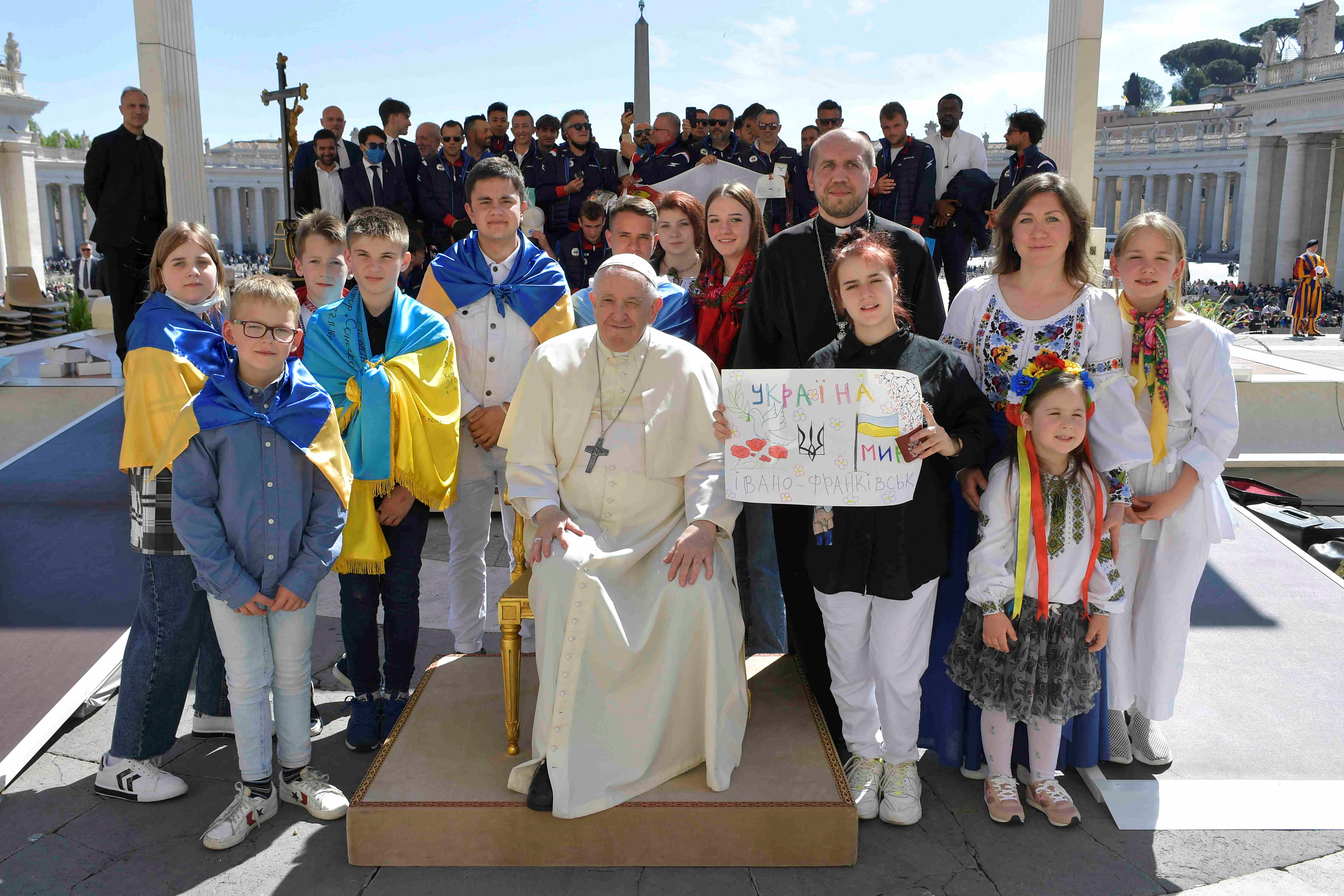 El papa Francisco posa para una foto junto a niños envueltos en banderas ucranianas durante la audiencia general semanal en la Plaza de San Pedro del Vaticano, el 27 de abril de 2022. Vatican Media/Handout via REUTERS