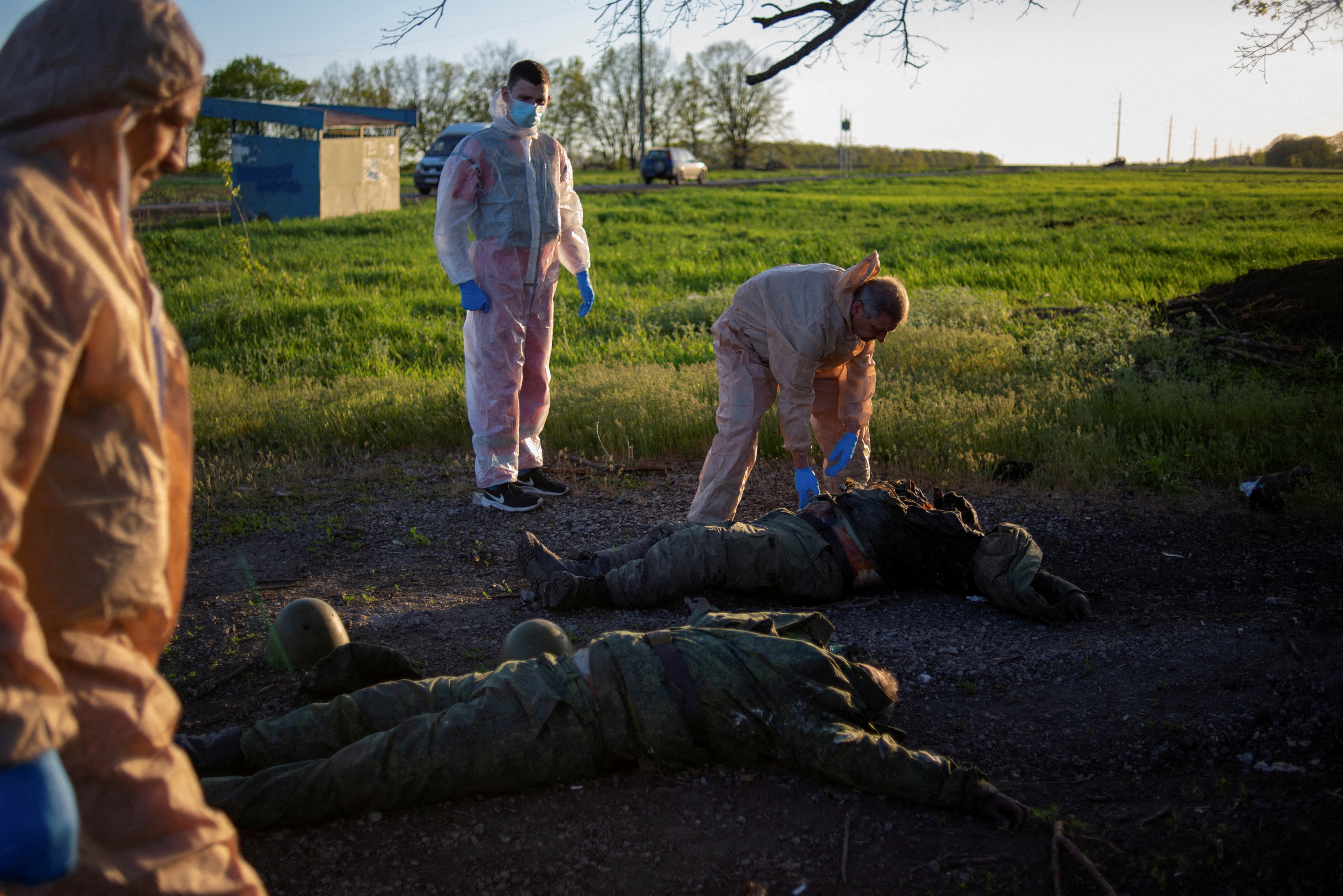 Un grupo de voluntarios recogen los cuerpos de soldados rusos en la villa de Vilkhivka, en la región de Kharkiv, reconquistada por las fuerzas ucranianas. REUTERS/Julia Kochetova