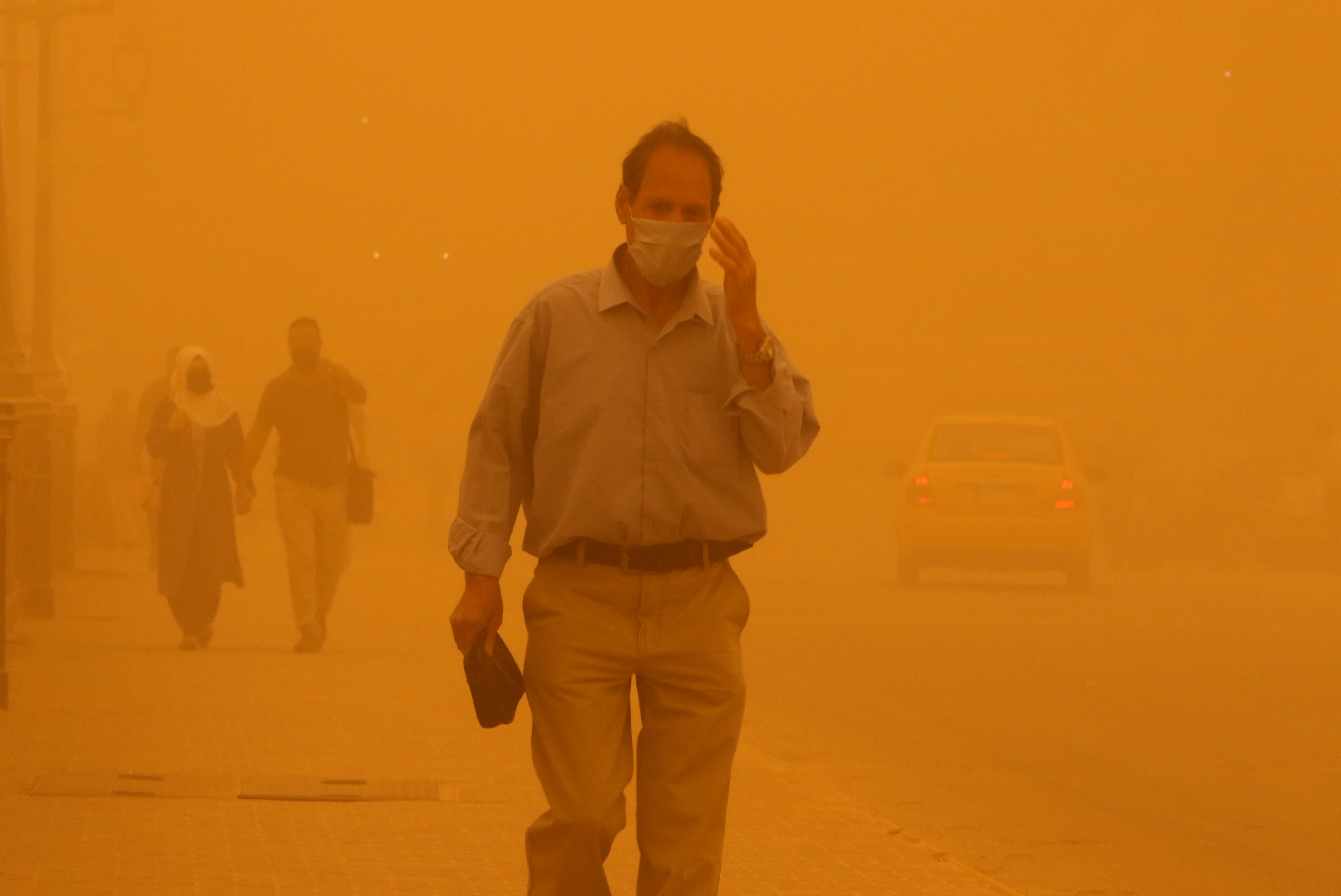 Un hombre con una máscara camina sobre un puente durante una tormenta de arena en Bagdad, Irak, el 16 de mayo de 2022. REUTERS/Ahmed Saad
