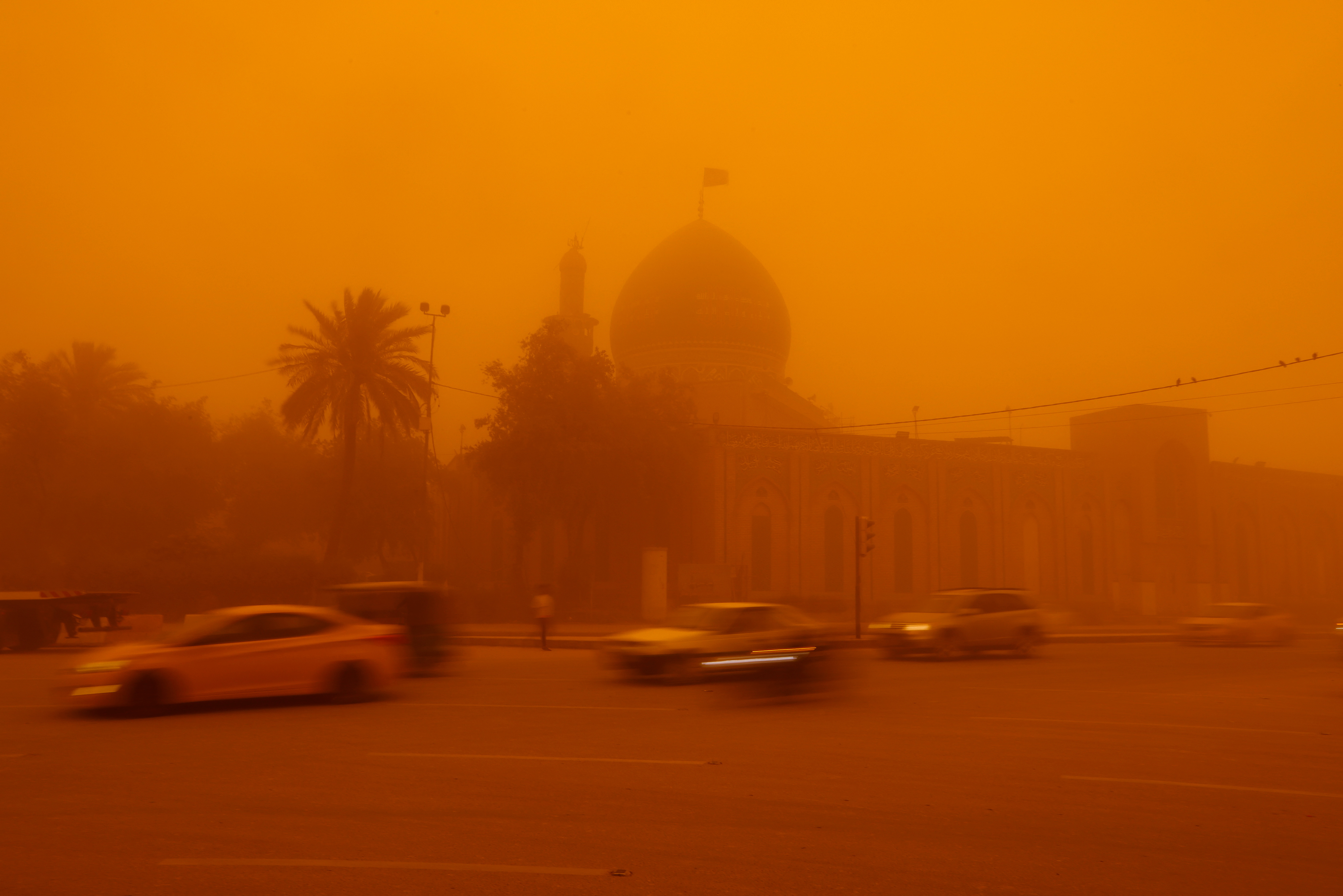 Autos pasan por una mezquita en medio de una tormenta de arena en Bagdad, Irak, el 16 de mayo de 2022. REUTERS/Ahmed Saad